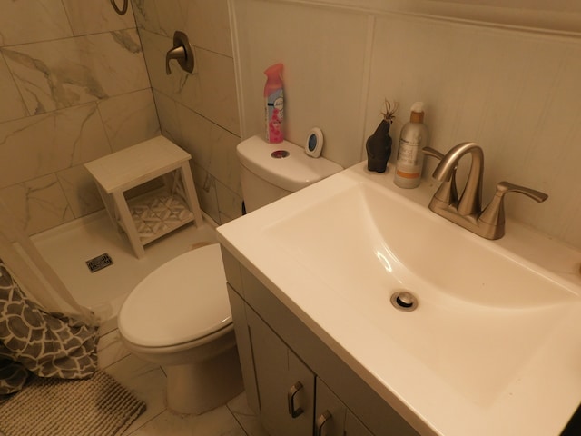 bathroom featuring a shower, tile patterned flooring, toilet, and vanity