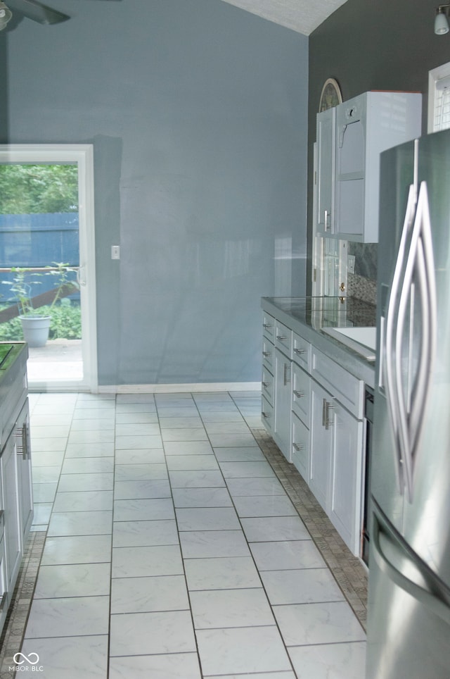 kitchen with stainless steel fridge, sink, ceiling fan, and white cabinets