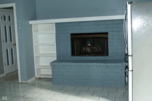 interior details featuring a fireplace and stainless steel fridge