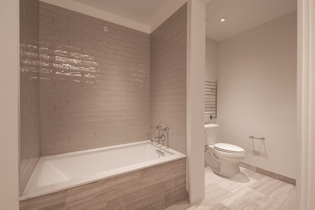 bathroom featuring a relaxing tiled tub and toilet