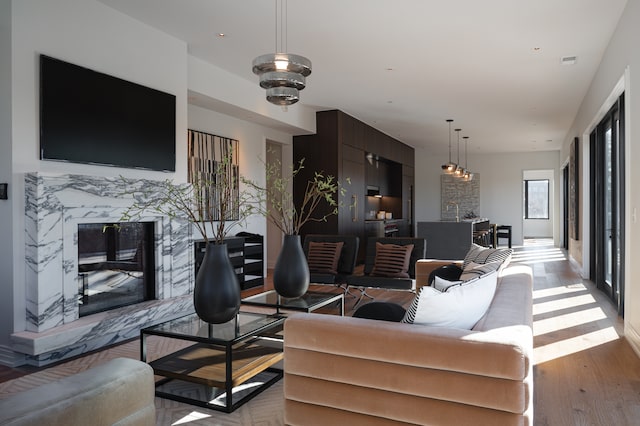 living room with light hardwood / wood-style floors and a premium fireplace