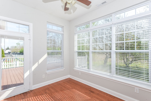 unfurnished sunroom featuring ceiling fan and a wealth of natural light