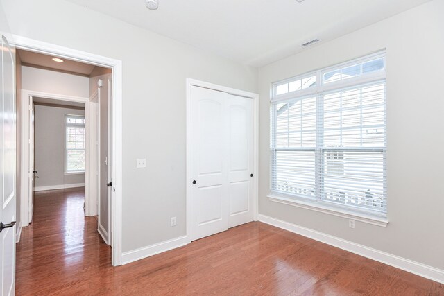 unfurnished bedroom with a closet and dark hardwood / wood-style floors