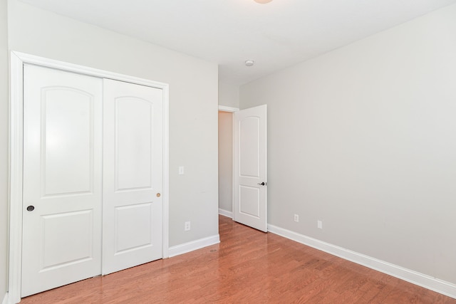 unfurnished bedroom with a closet and light wood-type flooring