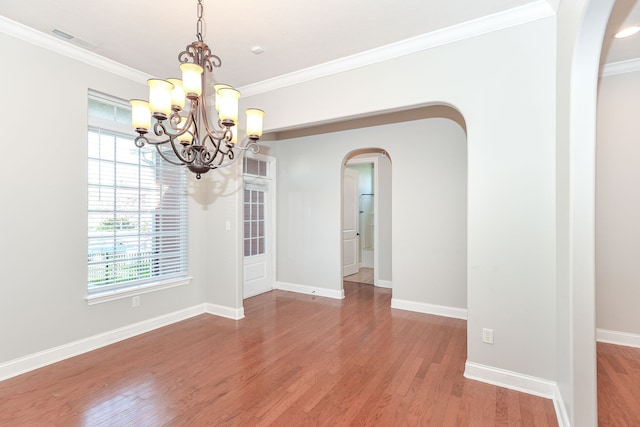 spare room with dark wood-type flooring, a notable chandelier, and ornamental molding