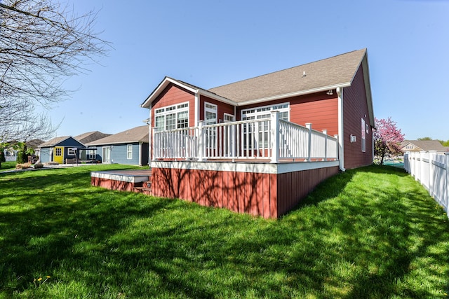 back of property with a wooden deck and a lawn