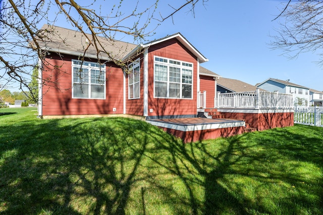 rear view of property with a deck and a yard