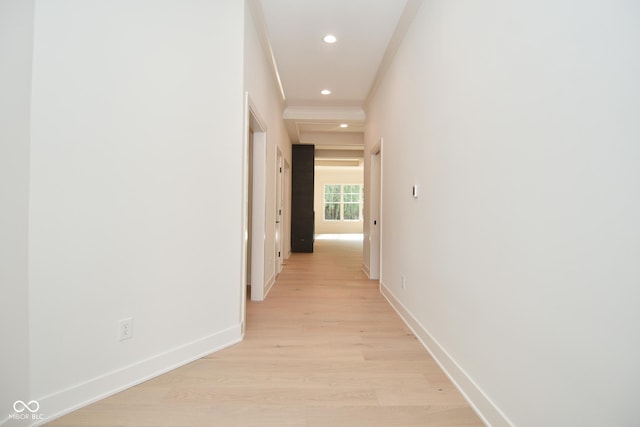 hallway with light wood-type flooring and ornamental molding