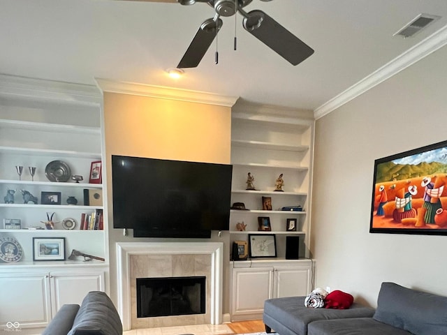 living room with a fireplace, built in features, and crown molding