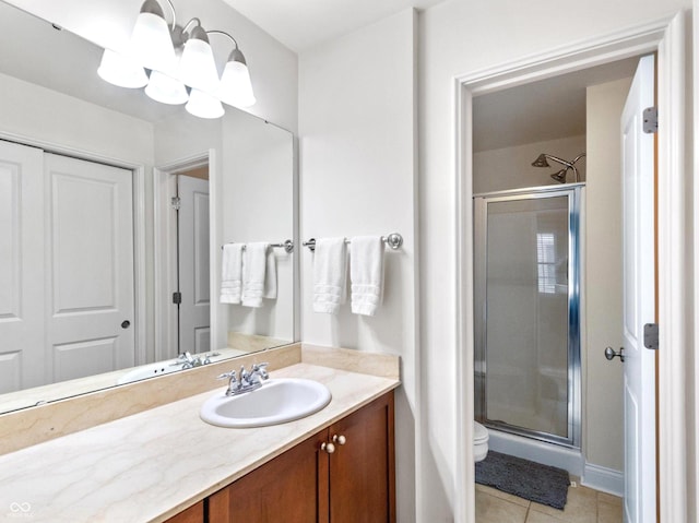 bathroom featuring tile patterned flooring, vanity, a shower with door, and toilet