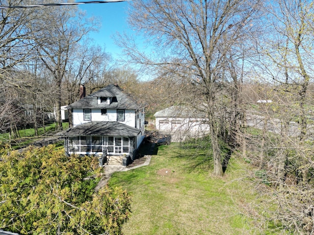 back of property featuring stucco siding, a lawn, a chimney, and a sunroom