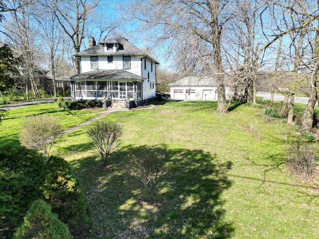 view of yard featuring a garage, an outdoor structure, and a sunroom