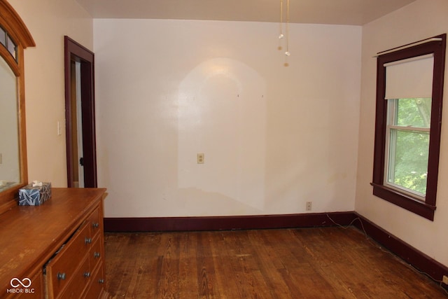 unfurnished room with dark wood-style floors and baseboards