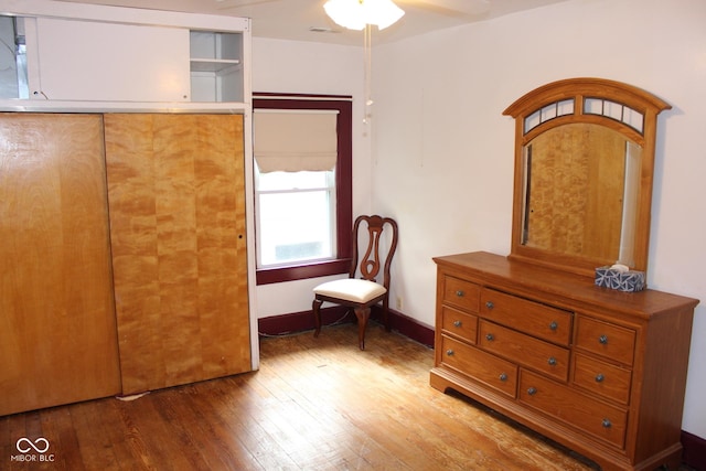 unfurnished bedroom with ceiling fan, wood-type flooring, and a closet