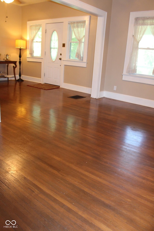 foyer entrance featuring wood finished floors, baseboards, and ceiling fan