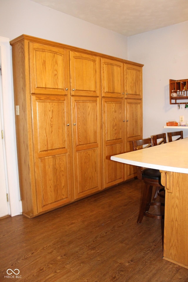 kitchen with a breakfast bar and dark hardwood / wood-style floors