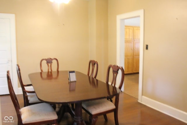 dining space with dark wood finished floors and baseboards