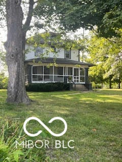 view of front of house with a front yard and a sunroom