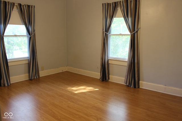 unfurnished room with wood finished floors and baseboards