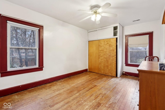 unfurnished bedroom featuring ceiling fan, light hardwood / wood-style flooring, and a closet