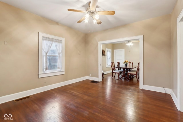 spare room with a ceiling fan, hardwood / wood-style flooring, baseboards, and visible vents