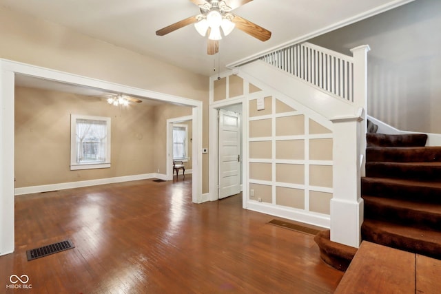 unfurnished living room featuring visible vents, stairway, a ceiling fan, and hardwood / wood-style flooring