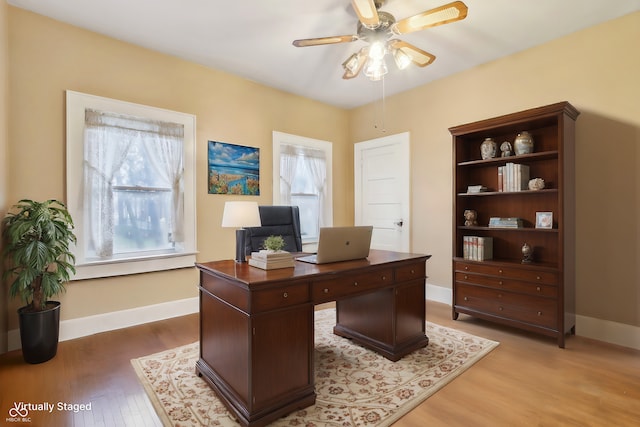 office space with light wood-style flooring, baseboards, and ceiling fan