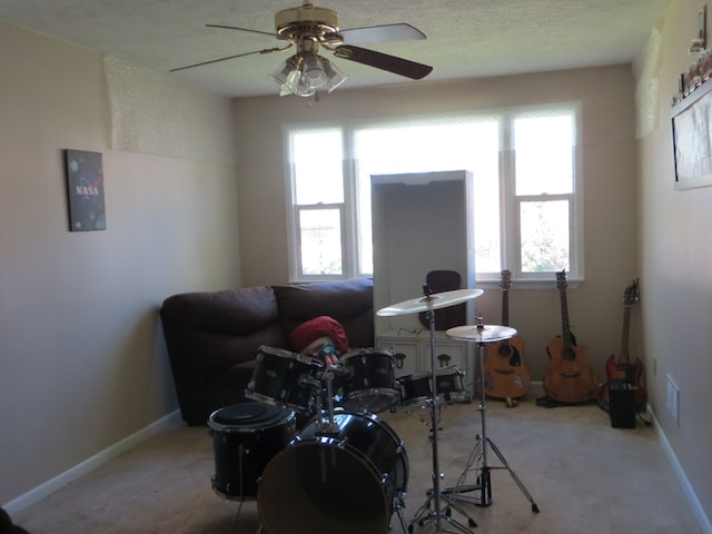 living area with plenty of natural light, ceiling fan, and carpet floors