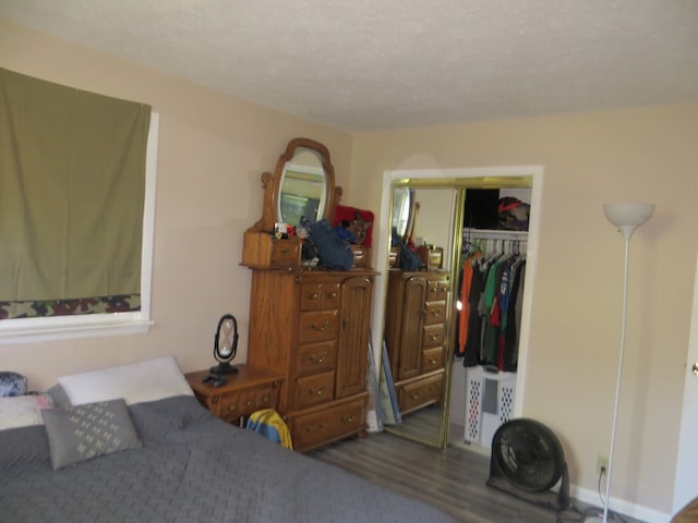 bedroom featuring dark wood-type flooring, a closet, and a textured ceiling