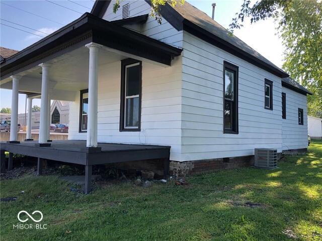 back of property featuring a lawn and central AC unit