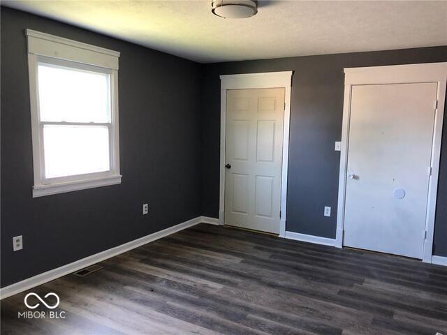 unfurnished bedroom with dark hardwood / wood-style flooring