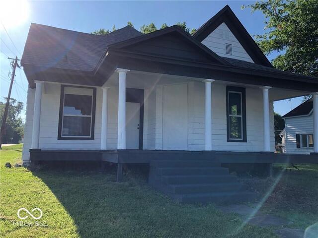 bungalow-style home featuring a front lawn and covered porch