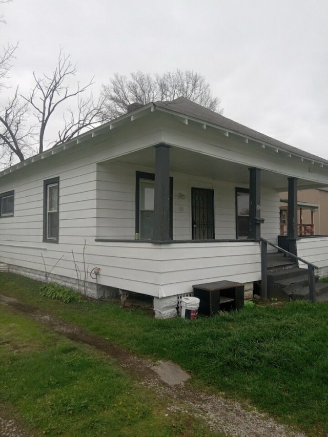 exterior space with covered porch and a yard