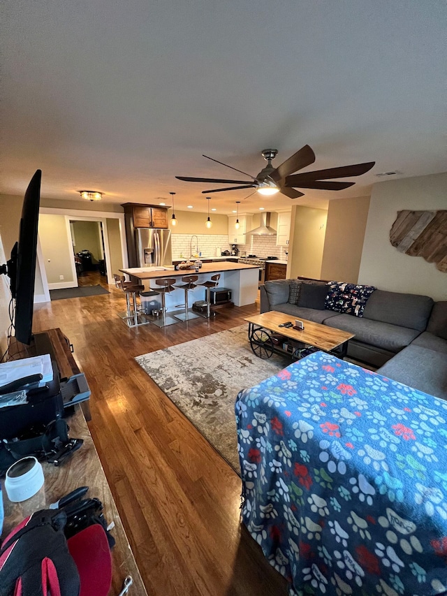 living room featuring wood-type flooring and ceiling fan