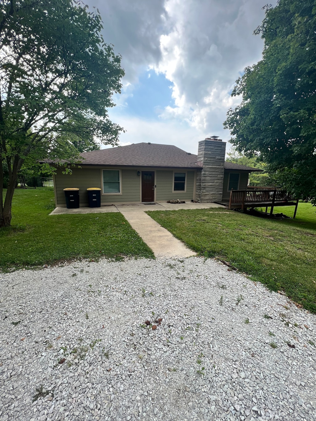 view of front of house with a wooden deck and a front lawn