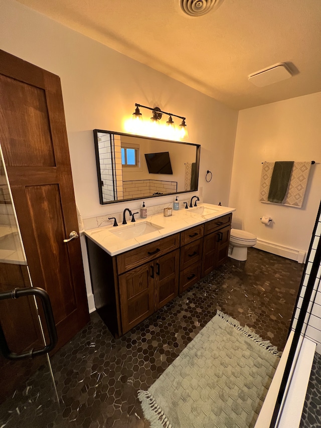 bathroom featuring toilet, dual vanity, and tile floors