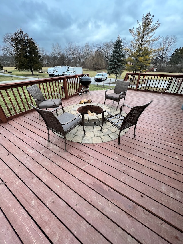 wooden terrace featuring an outdoor fire pit