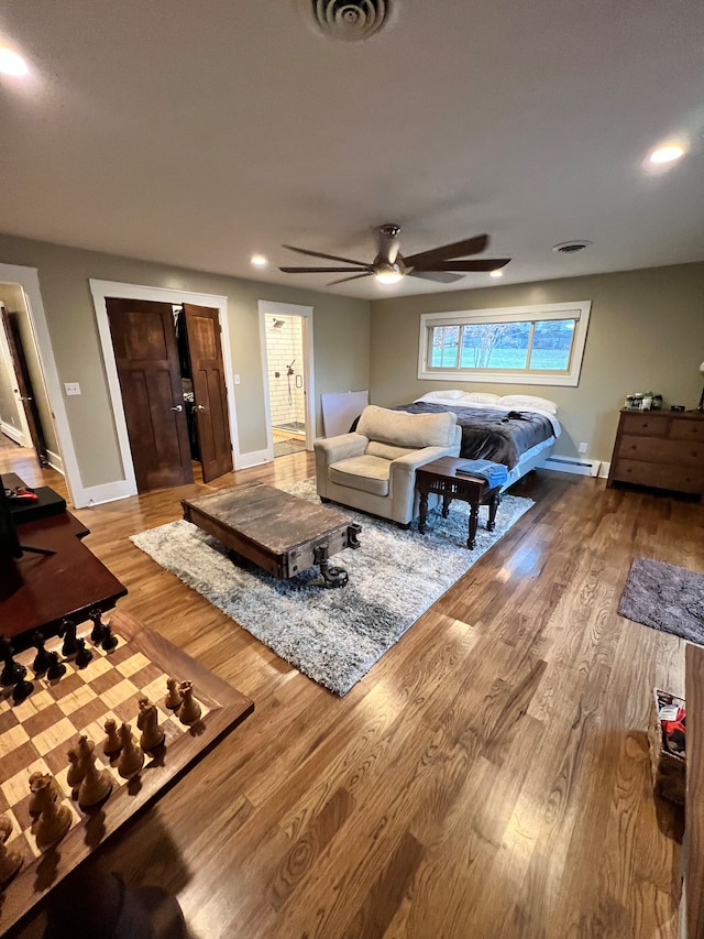 living room featuring ceiling fan, baseboard heating, and light hardwood / wood-style floors