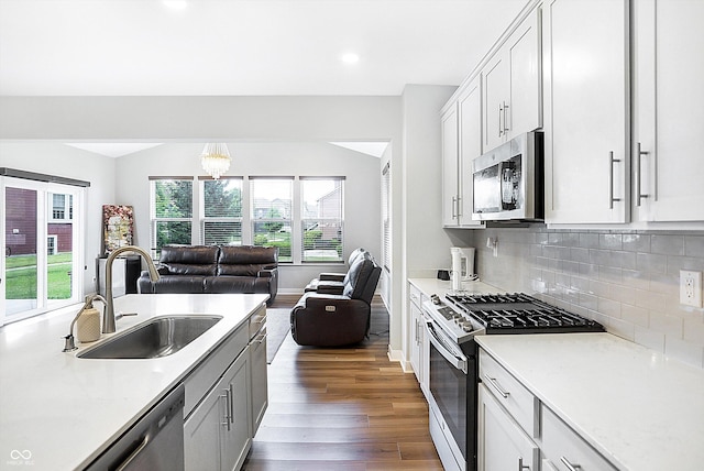 kitchen featuring sink, appliances with stainless steel finishes, white cabinetry, dark hardwood / wood-style floors, and tasteful backsplash