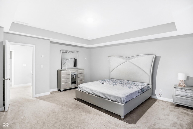 carpeted bedroom featuring a raised ceiling