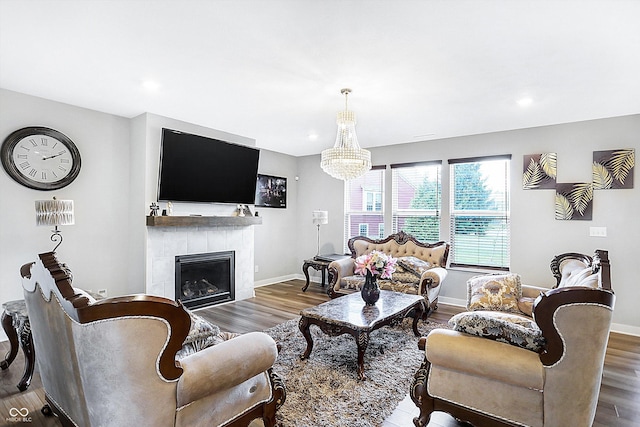 living room with an inviting chandelier, dark hardwood / wood-style flooring, and a tile fireplace