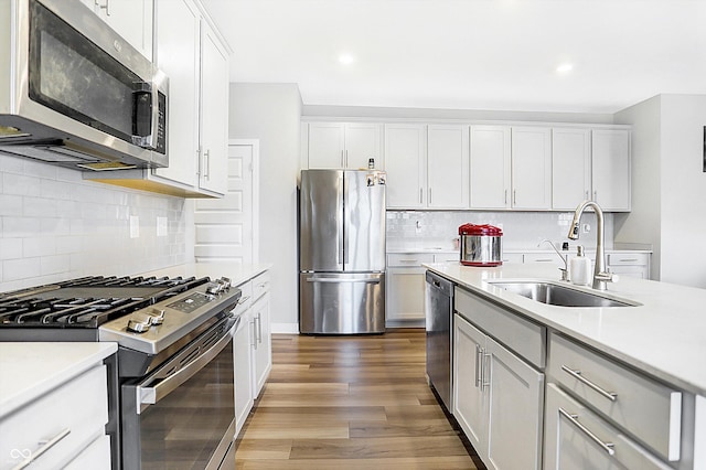 kitchen featuring white cabinetry, sink, hardwood / wood-style floors, and appliances with stainless steel finishes