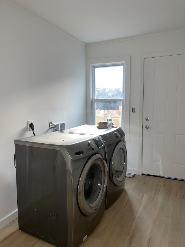 laundry area with washer and clothes dryer, electric dryer hookup, light hardwood / wood-style floors, and hookup for a washing machine