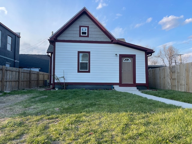 view of front of home with a front yard and central air condition unit