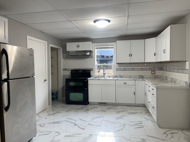 kitchen with stainless steel refrigerator, range with electric cooktop, white cabinets, a paneled ceiling, and sink