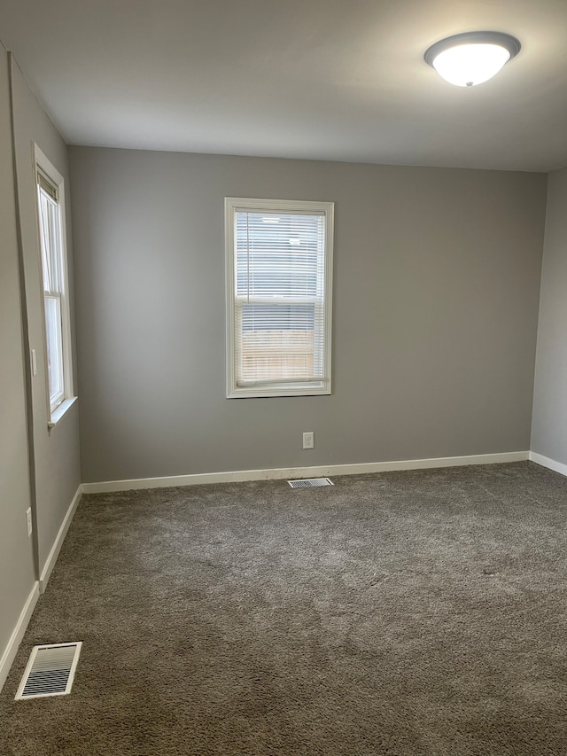 empty room featuring dark colored carpet