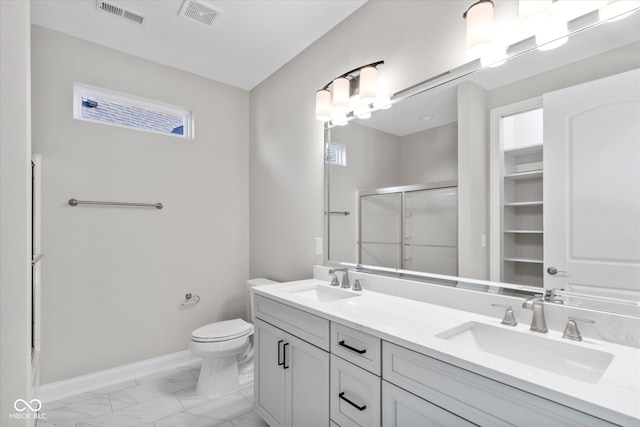 bathroom featuring vanity, a shower with shower door, and toilet