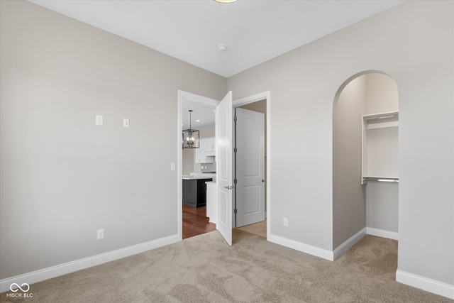 unfurnished bedroom featuring carpet, a spacious closet, and a closet