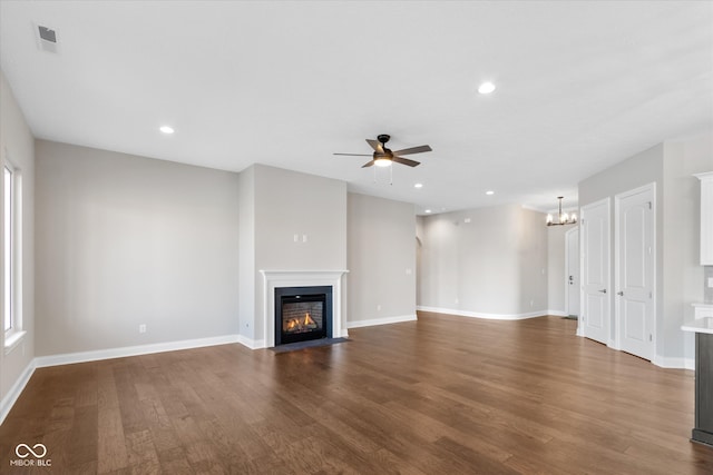 unfurnished living room with hardwood / wood-style flooring and ceiling fan with notable chandelier