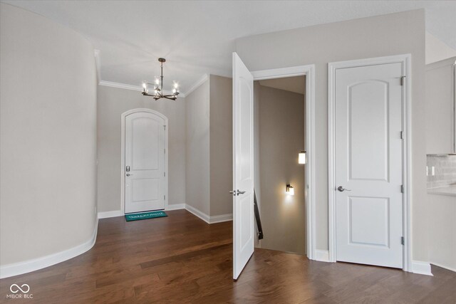 entrance foyer featuring an inviting chandelier, dark hardwood / wood-style floors, and crown molding